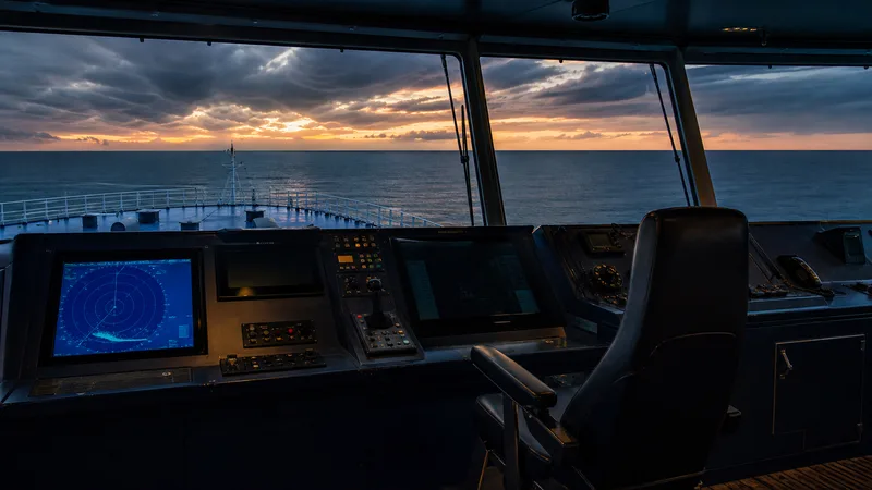 Navigation bridge looking toward the bow and a dark ocean horizon