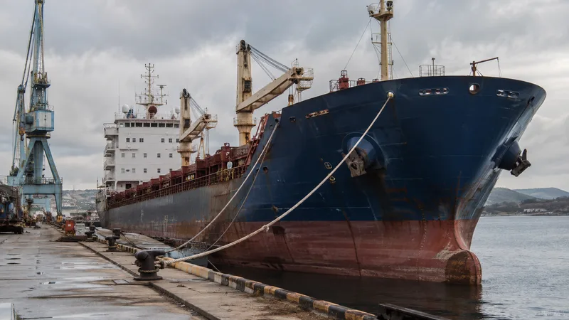 Older cargo vessel with weathered hull alongside a repair quay